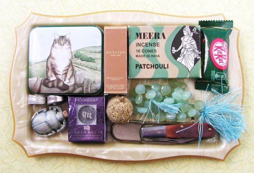 a few of my favorite things: fat cat tin, youth dew amber nude mini, incense, green tea kitkat, spoon rings, scarab amulet, urban decay moondust eyeshadow, poofball thing I found on the ground, chalcedony briolettes, bigass safety pin and dad's pocket knife.